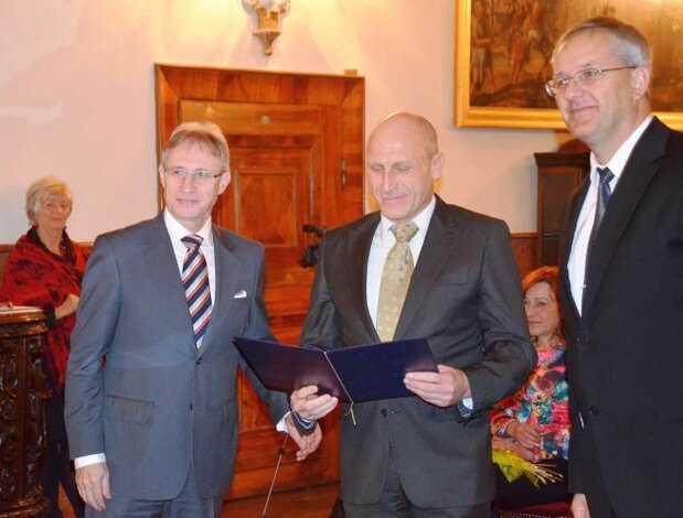Gabriel Rehák preberá "Ďakovný list" z rúk prof. Leikerta(vľavo) a p. Ťažkého (vpravo)